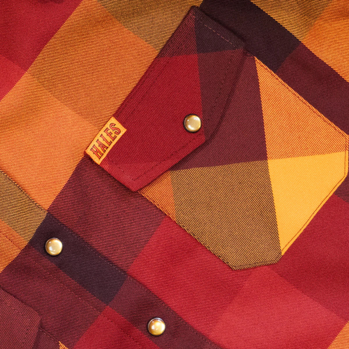 Worn by lawmen, cowboys, and outlaws alike, our "Sheriff" flannel guarantees a stylish and sharp look that will outlast your day! This long-sleeve pearl snap shirt features a timeless plaid pattern and the same unbeatable comfort of Hales Legendary Flannels that you already know and love. With a modern twist on a traditional western shirt, it boasts vibrant colors and our exclusive poly/spandex blend for ultimate comfort, making it an essential for any contemporary cowboy. The vibrant golden pearl snaps