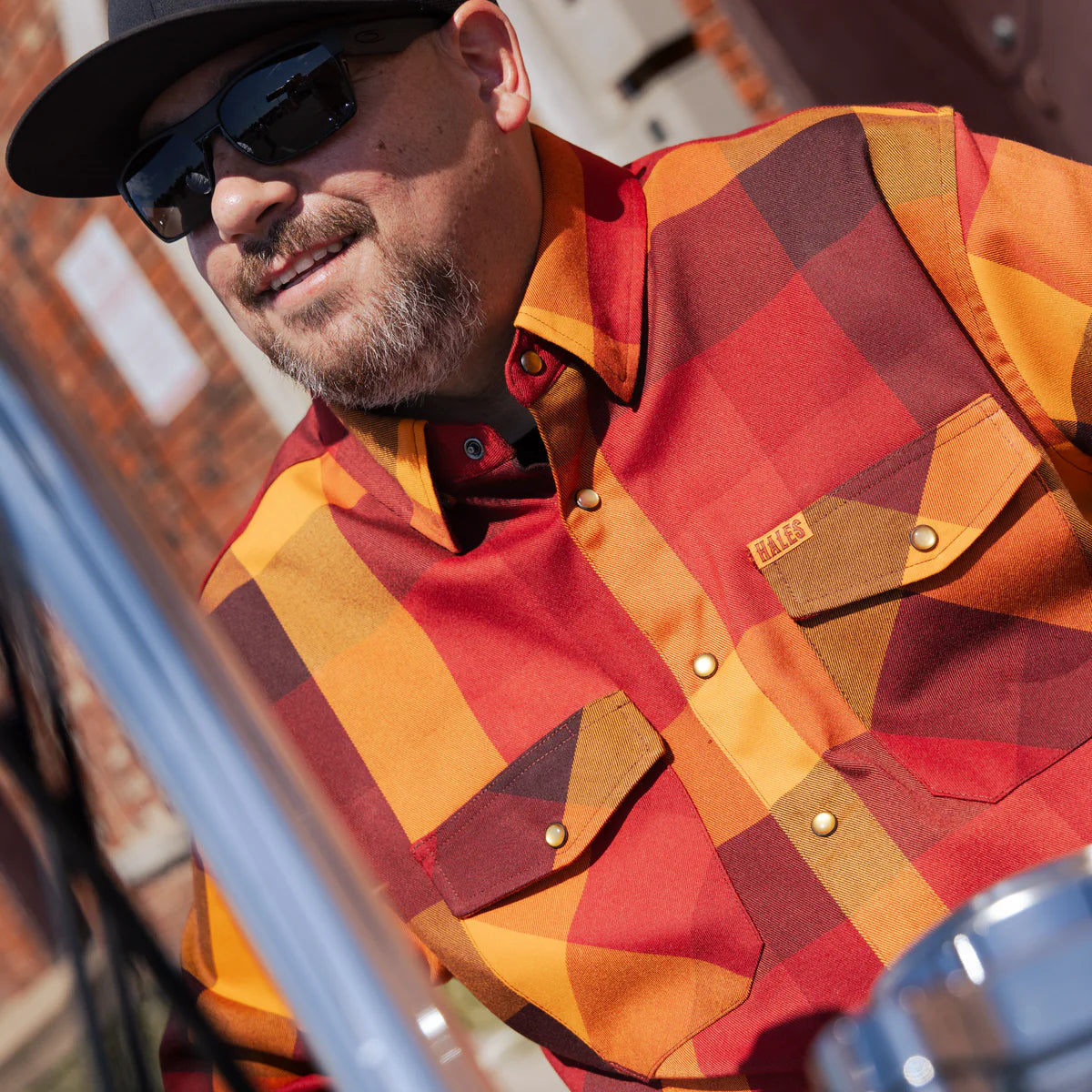 Worn by lawmen, cowboys, and outlaws alike, our "Sheriff" flannel guarantees a stylish and sharp look that will outlast your day! This long-sleeve pearl snap shirt features a timeless plaid pattern and the same unbeatable comfort of Hales Legendary Flannels that you already know and love. With a modern twist on a traditional western shirt, it boasts vibrant colors and our exclusive poly/spandex blend for ultimate comfort, making it an essential for any contemporary cowboy. The vibrant golden pearl snaps